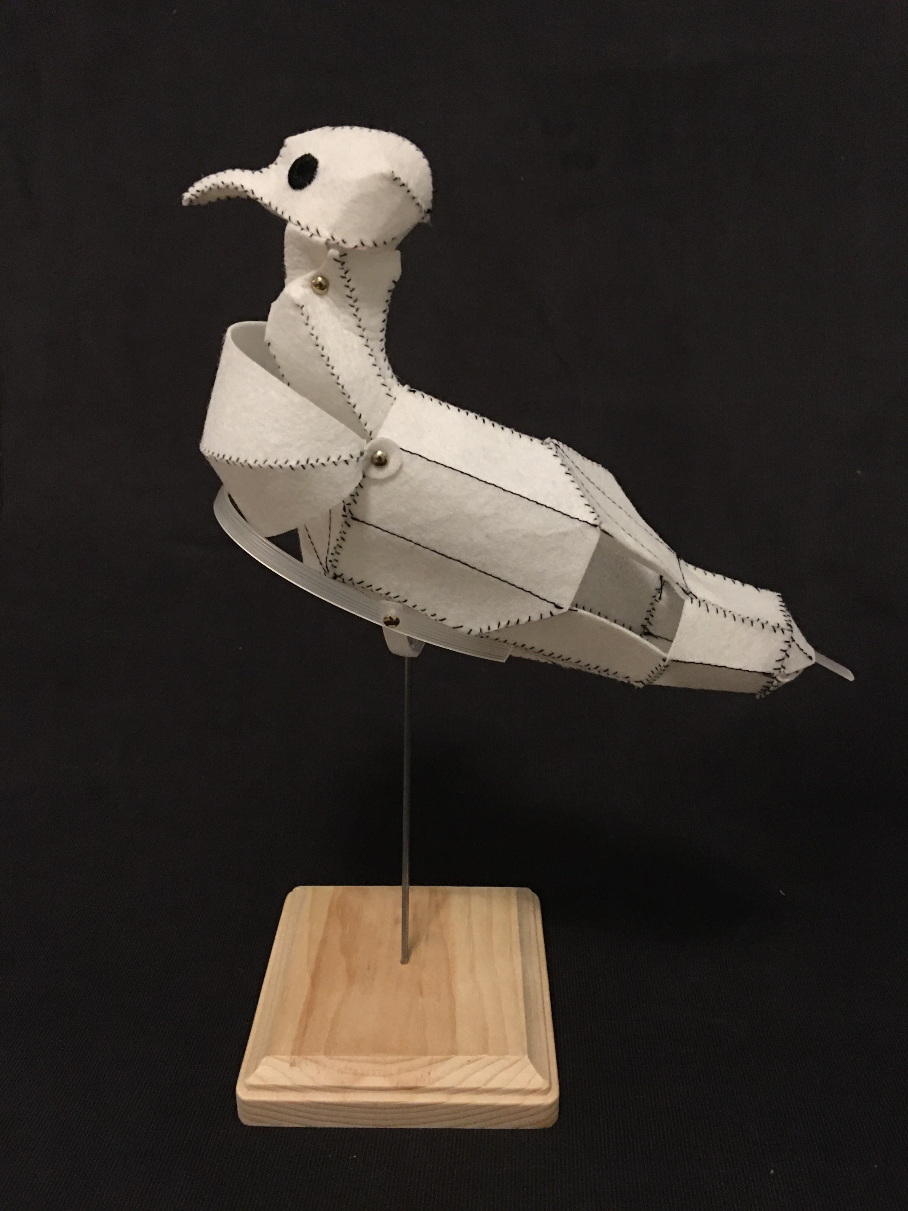 a model pigeon sewed from white interfacing with black contrast thread, profile view