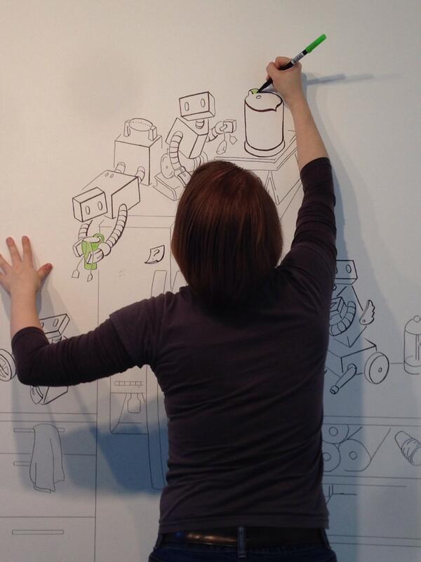 picture of the author from the back, drawing robots on a large wall mural in Brooklyn NYC for the Recurse Center